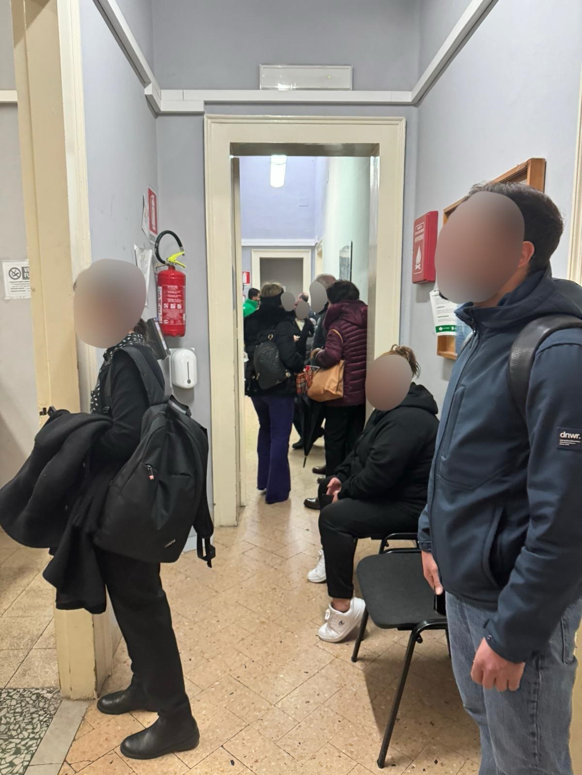 Corridoio aungusto e inadeguato dove si assiepano i cittadini